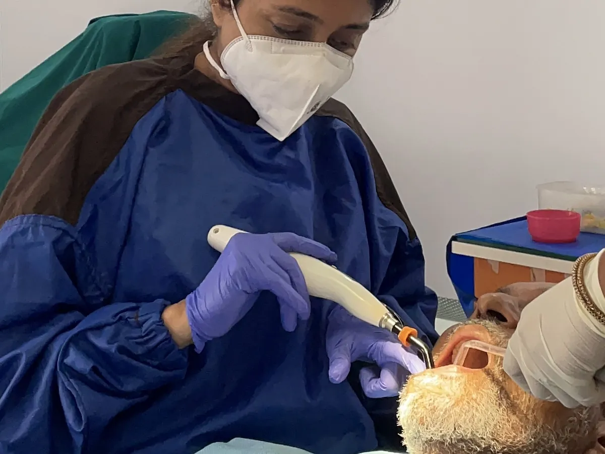 A dentist using a dental handpiece on a patient at Prudent Dental Clinic, Viman Nagar, Pune