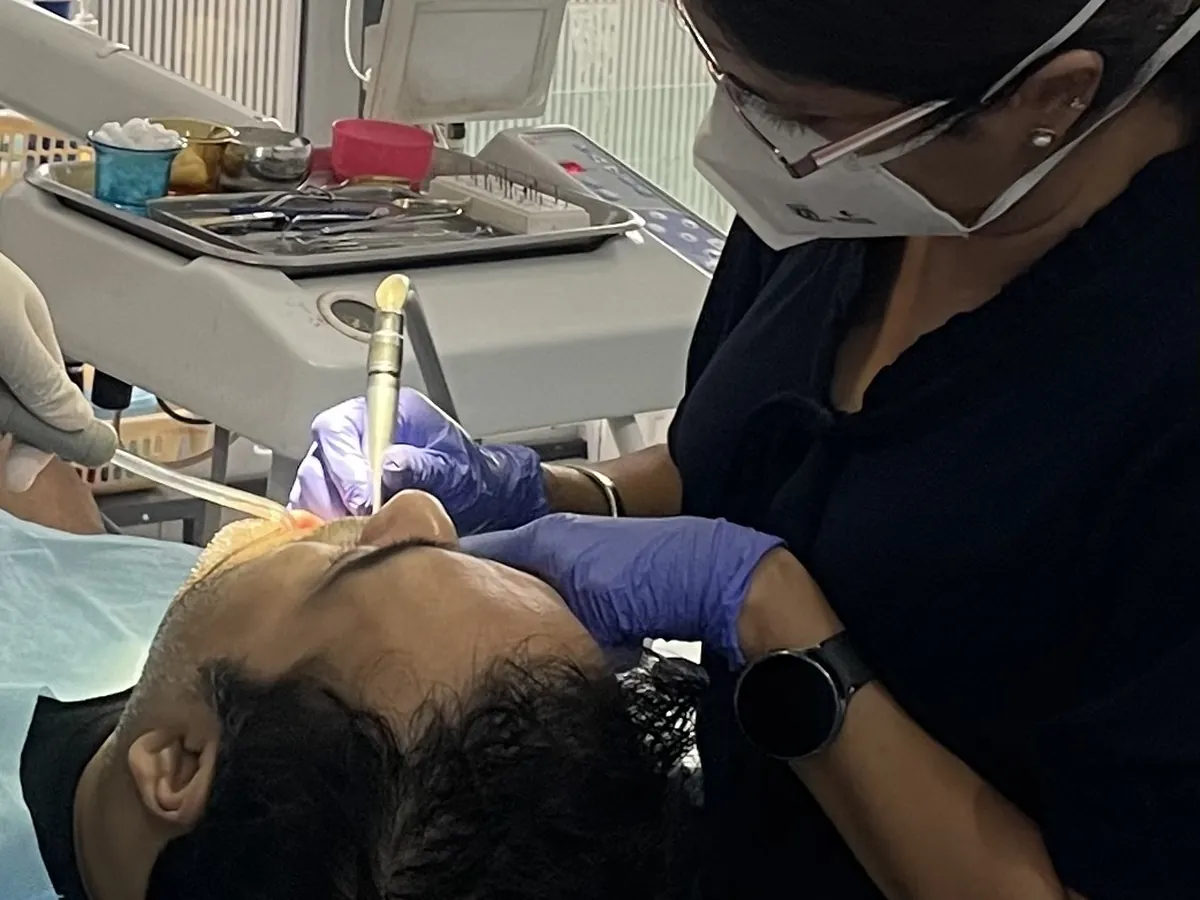 A dentist leaning over a patient during treatment at Prudent Dental Clinic, Viman Nagar, Pune