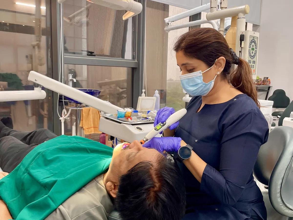 A dentist treating a reclining patient in the dental chair at Prudent Dental Clinic, Viman Nagar, Pune