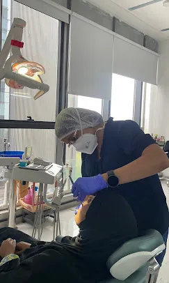 Dr. Puja Bansal performing a dental procedure in the operatory