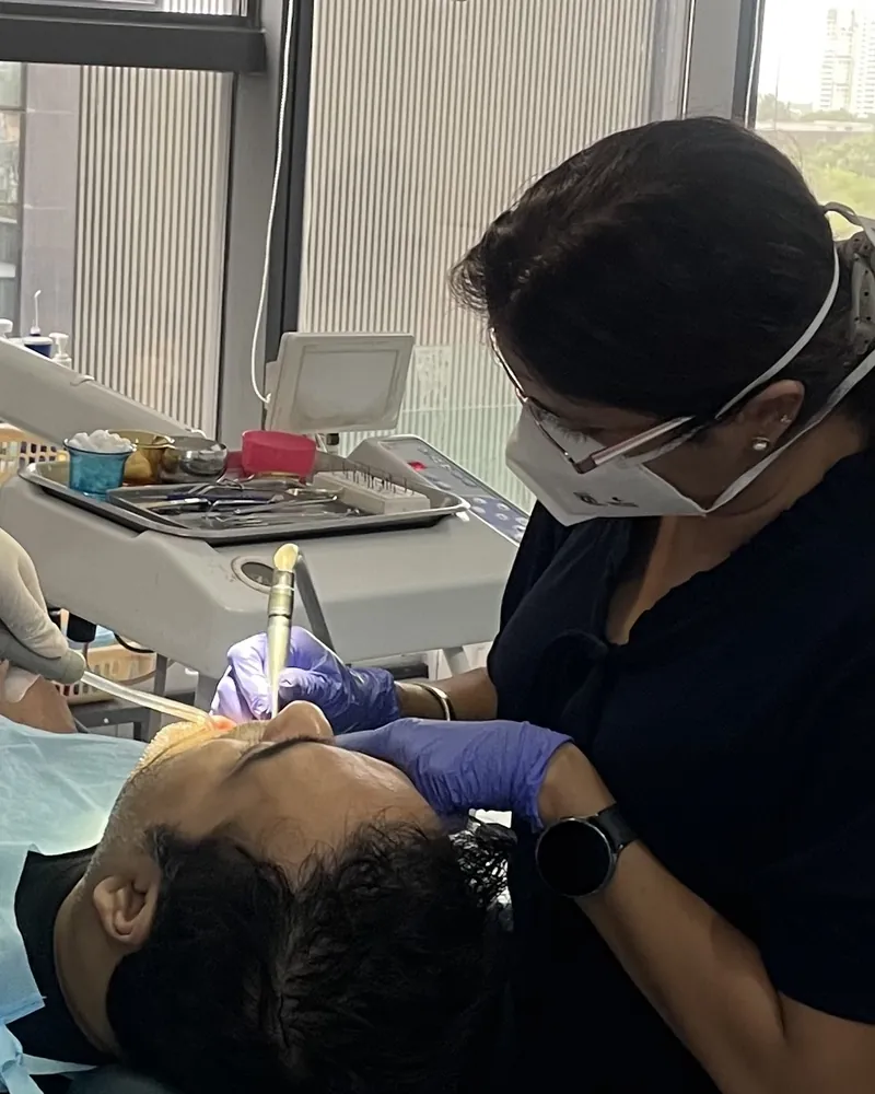 A dentist at Prudent Dental Clinic carrying out treatment with a handpiece
