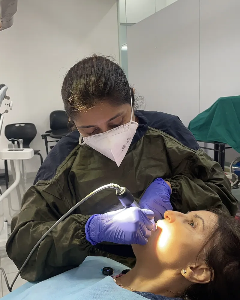 A dentist examining a patient under the operatory light