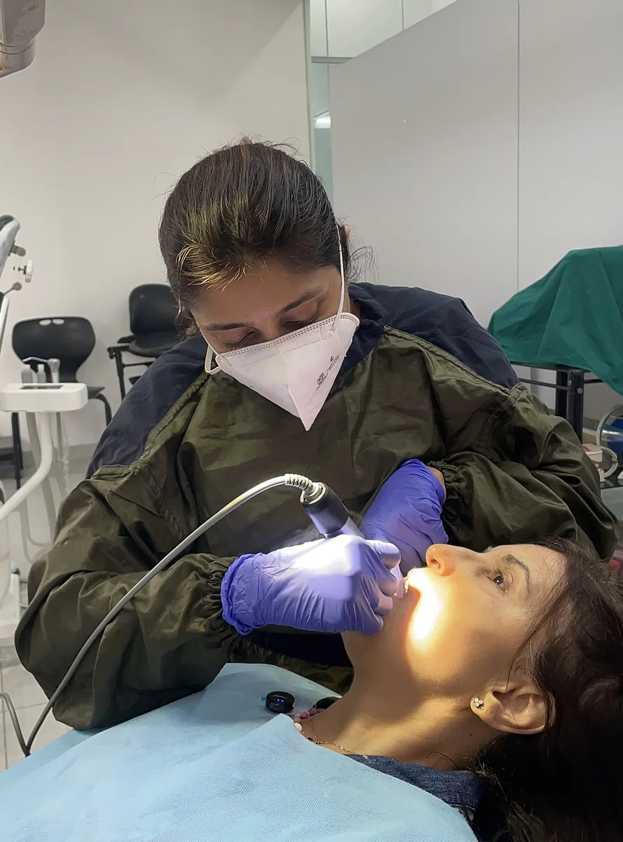 A patient receiving treatment under the dental light